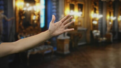 Hand of man indoors at museum room depicting thumb up sign and counting from one to five with fingers in a sequence against an ornate background, showcasing gesture in a classy setting.