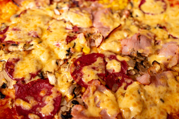 Delicious pizza topped with cheese, ham, and pepperoni slices
