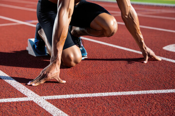 African male athlete ready to sprint on track in starting position