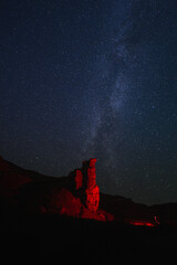 starry sky over a canyon illuminated by a red lantern