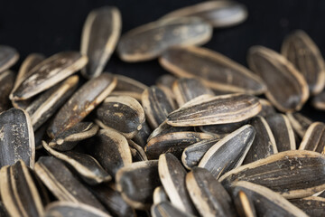 Pile of black roasted sunflower seeds on rustic table, nut concept,
