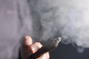 Man holding a cigar in his hand close-up