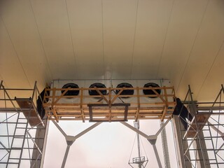 Scaffolding supports a large air conditioning unit inside a commercial building for maintenance.