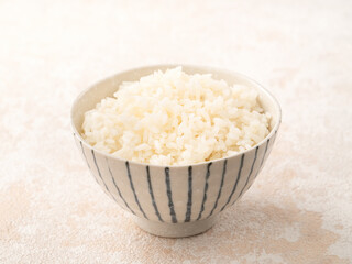A cookd steamed white rice in a Traditional bowl.
