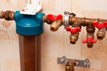 Plumbing system detail showing a water filtration unit and several copper pipes with valves.