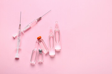 Medical ampules with syringes on pink background