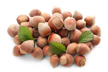 Shelled hazelnuts with leaves on white background