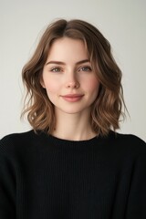 Obraz premium Portrait of a Young Woman with Shoulder-Length Brown Hair Wearing a Black Sweater