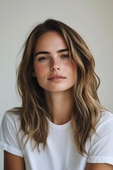 Fototapeta premium Portrait of a Young Woman with Long Brown Hair and Minimal Makeup