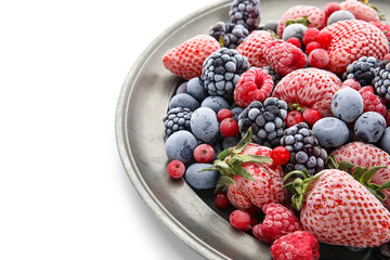 Plate with frozen berries on white background