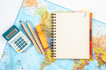 Notebook with mock up page, calculator, notebook and textbooks on the world map. Concept of world...