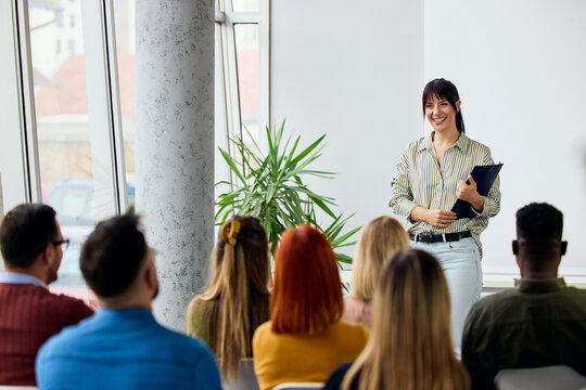 Speaker Engaging an Audience During a Training Session in a Modern Office Space
