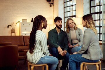 Group of Four People Engaged in Discussion in Modern Casual Setting
