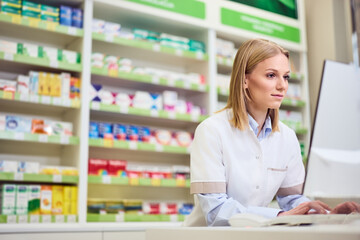 Fototapeta premium Professional Pharmacist Working on Computer In Modern Pharmacy Store