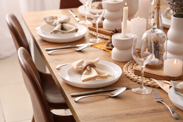 Elegant table setting with folded napkins, cutlery and plates