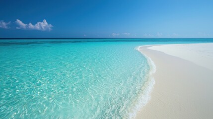 Idyllic tropical beach with crystal-clear turquoise water lapping a pristine white sand shore under a vibrant blue sky.