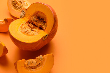 Cut fresh pumpkin on orange background