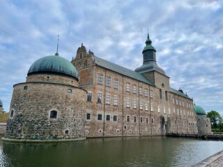 Fototapeta premium Vadstena castle in Vadstena, Sweden. Vadstena Castle is a Renaissance fortress located in Vadstena, Sweden. It features large, rounded stone turrets and a distinctive central tower with a spire. 