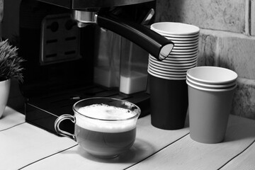 Cup of coffee and coffee machine, making coffee, black and white image