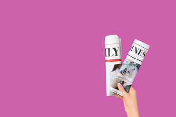 Woman with rolled newspapers on purple background