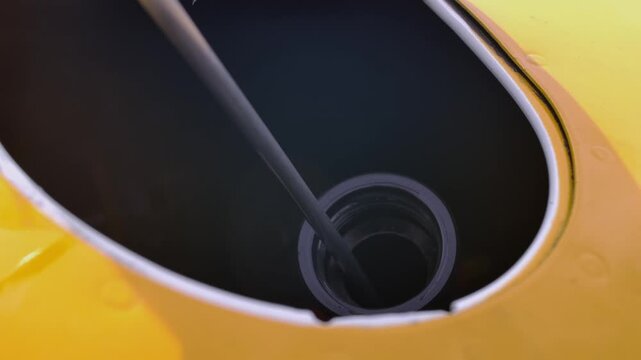 Pilot Checks Oil Level Airplane Piston Engine with Dipstick Close Up