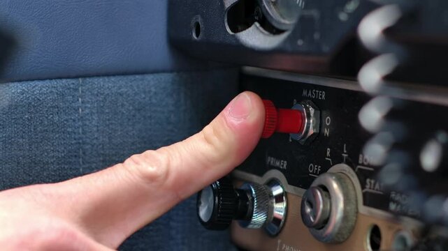 Close Up Pilot Actuating Master Switch in Airplane Cockpit - Push Pull