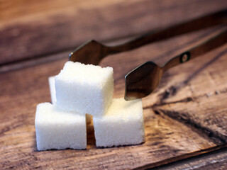Cubes of refined sugar on wooden background