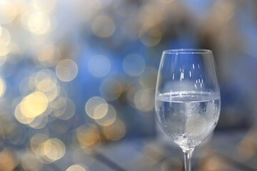 a glass of white wine, a background under the summer sun, a bokeh and sun glare, a blurred abstract background