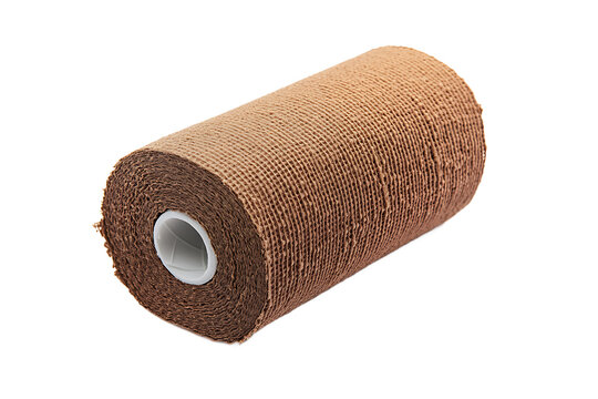 A close up shot of a roll of brown elastic bandage with a white inner core on a black background