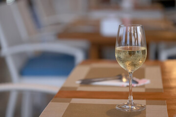 a glass of cold white wine and serving in the restaurant