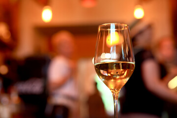 a glass of cold white wine and serving in the restaurant