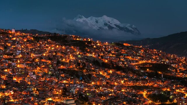 Day to night timelapse of La Paz cityscape and Illimani mountain in Bolivia, South America, zooming in. 
