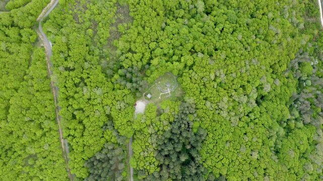 Overhead drone shot of the ancient ruins of Mishkova Niva Tomb in the middle of a woodland in an ecological reserve on top of Strandzha Mountain in Bulgaria.