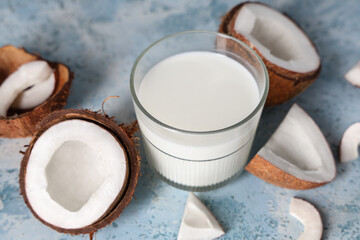Glass of tasty fresh coconut milk on blue grunge background, closeup