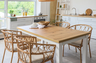 Dining table with wicker chairs in kitchen