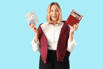 Mature female math teacher with different calculators on blue background