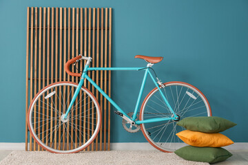 Screen, cushions and bicycle near blue wall in room