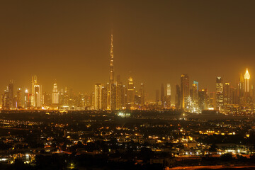 Fototapeta premium Nightscape of Dubai, featuring the majestic Burj Khalifa towering above an array of sparkling skyscrapers.