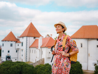 Beautiful woman walking of Varazdin streets during summer day in old, historical city center. Tourist exploring the beautiful streets, view on city from fortess