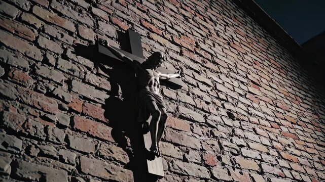 Shadowed cross on brick wall reveals depth and texture in moving light sequence
