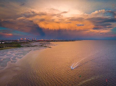 Aerial view of a dramatic storm cloud a over small boat and city skyline