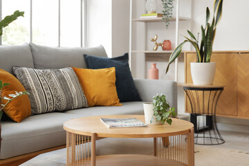 Fototapeta premium Interior of stylish living room with cushions on sofa and table