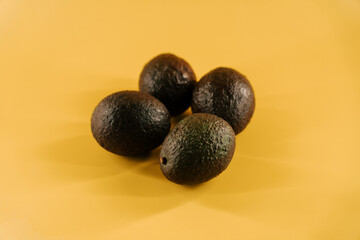 Fresh avocados arranged on a bright yellow surface for a healthy meal idea