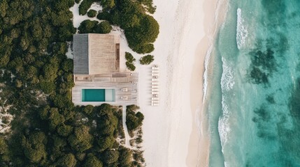 A luxury beachfront hotel with a white sandy beach, elegant lounge chairs, and turquoise water.