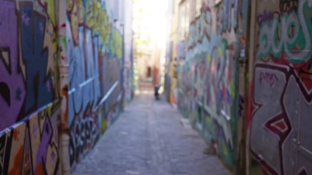 Blurry urban alley with colorful graffiti creating an artistic and vibrant street scene in an outdoor ghetto setting.