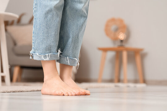 Young woman with flat feet on floor at home, closeup