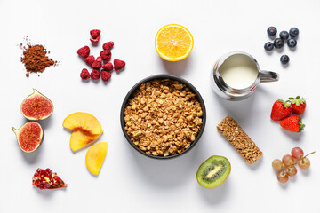 Bowl with muesli, milk and ingredients on white background