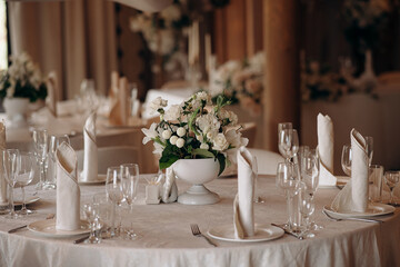 A round table set with elegant glassware and floral centerpieces in an event setting