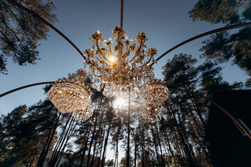 Elegant crystal chandeliers glowing outdoors at dusk