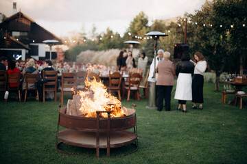 Rustic fire pit burning at an outdoor evening gathering